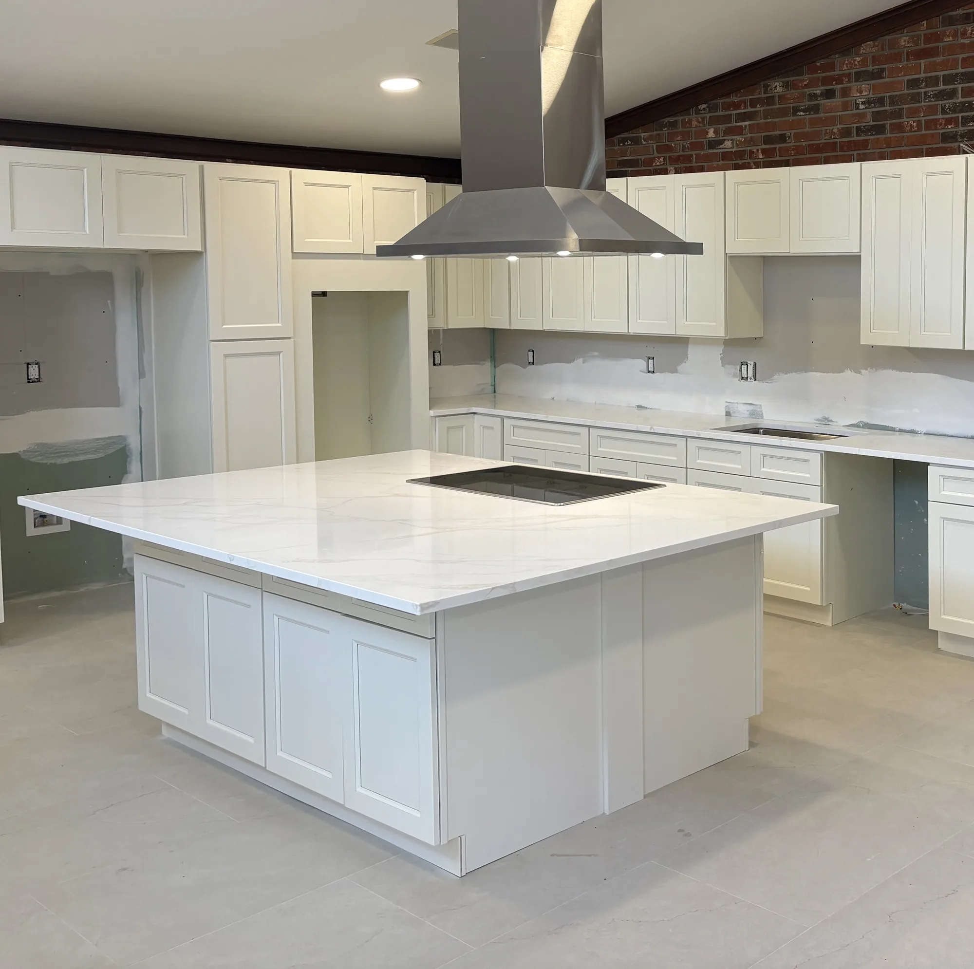 Installed wall cabinets and hood run above the range
